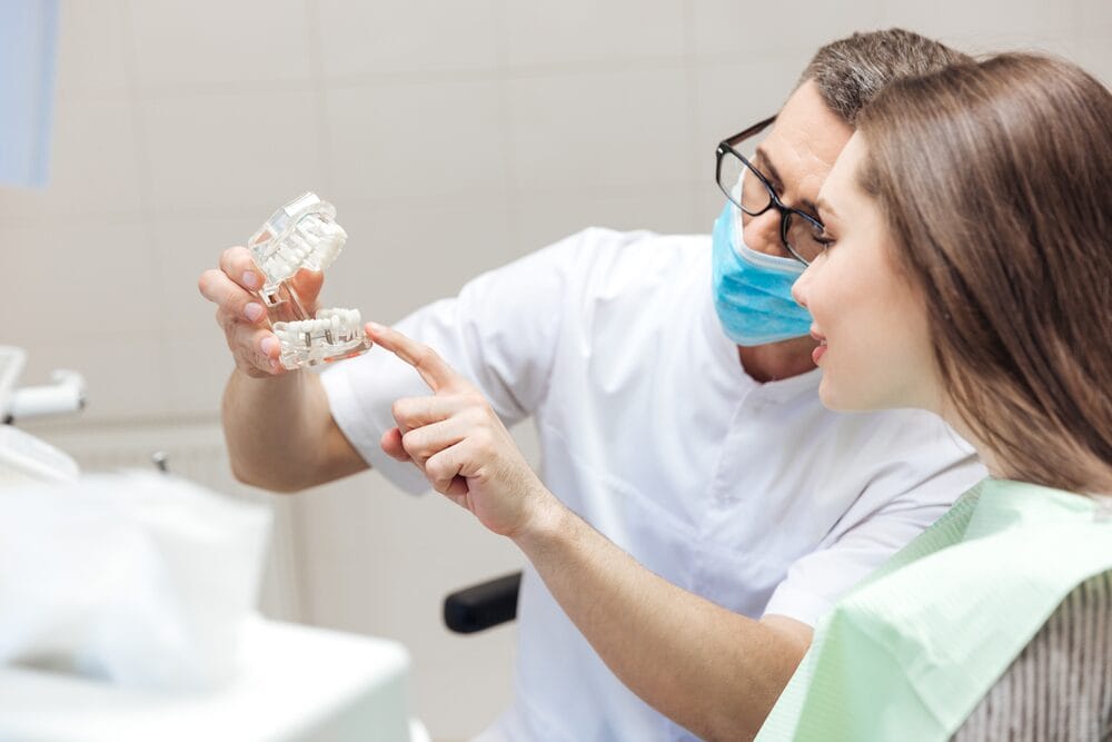 Dis hekimi tarafindan hastaya tedavi surecini anlatmak icin dental model uzerinde gosterim yaptigi sahne